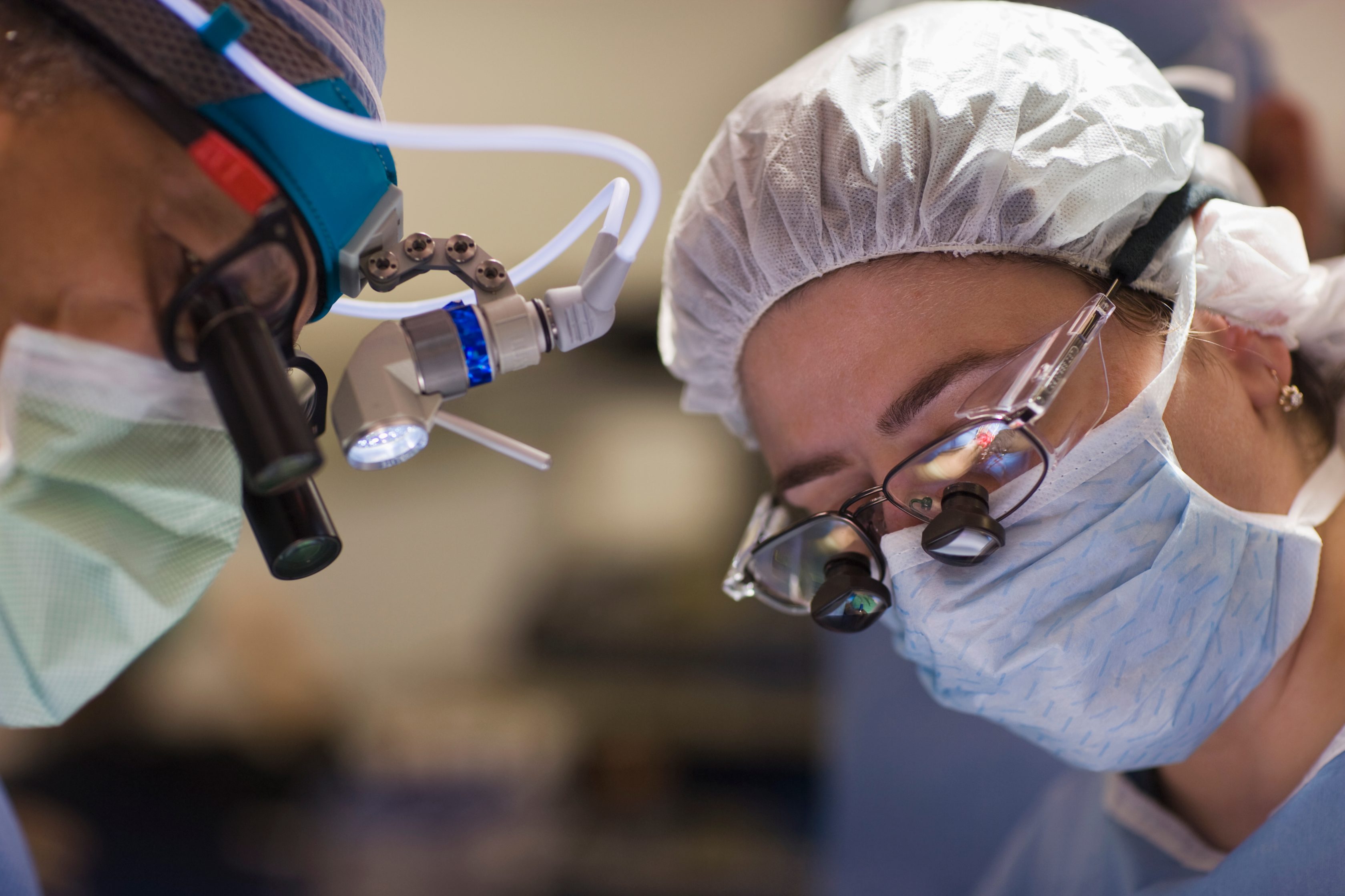 Man with mask is putting liquid into glasses within a laboratory